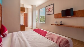 A modern hotel room with a large bed, a TV, a red and white patterned bedspread, and a view of the outdoors through the windows. - Townhouse Oak Medan near Universitas Sumatera Utara formerly Raz Residence (Medan)