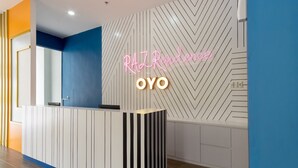 A reception desk with a neon sign reading "RAZ Residence OYO" against a geometric-patterned wall. - Townhouse Oak Medan near Universitas Sumatera Utara formerly Raz Residence (Medan)