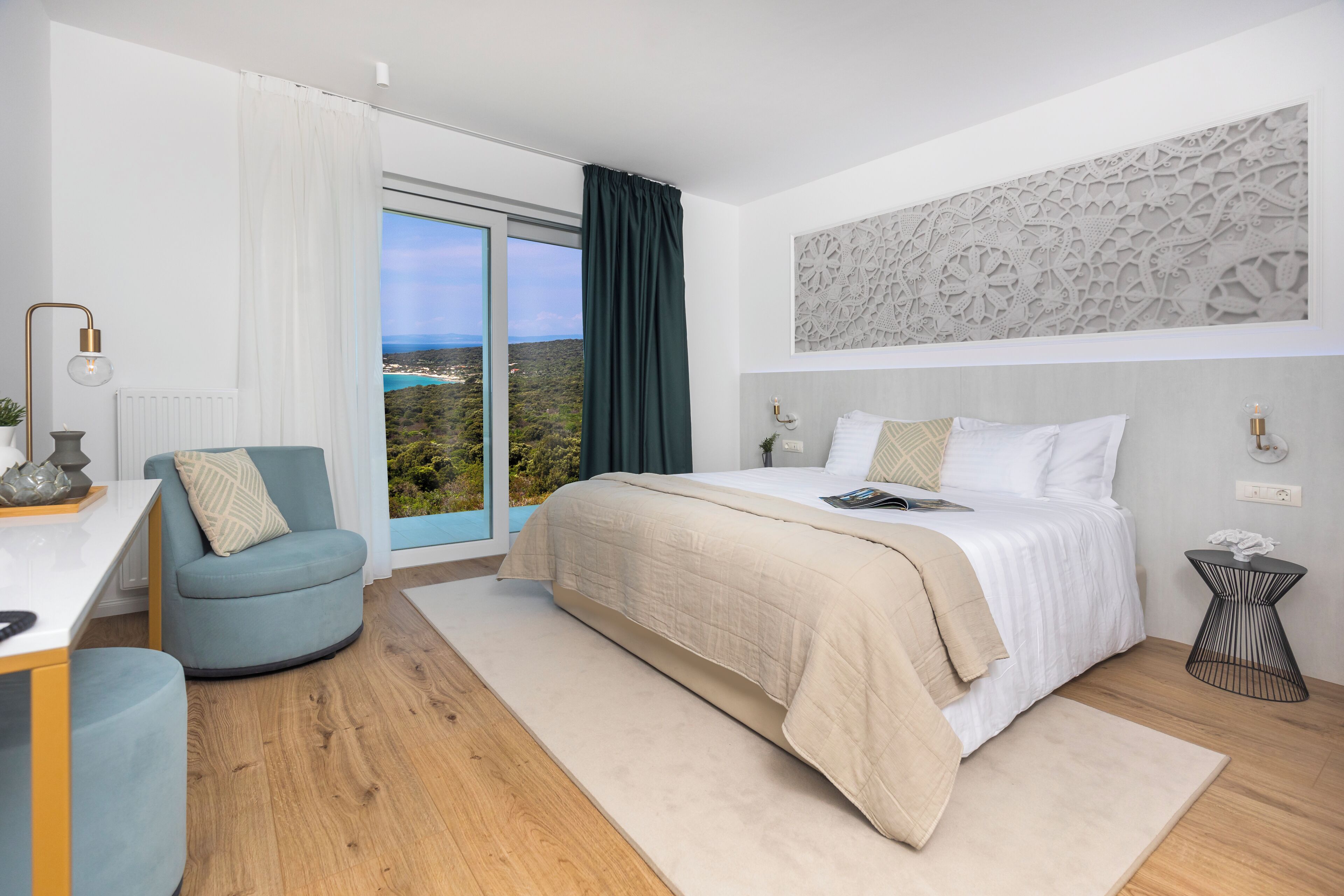 Une chambre moderne avec un grand lit, un bureau et une chaise. La fenêtre offre une vue sur un paysage.