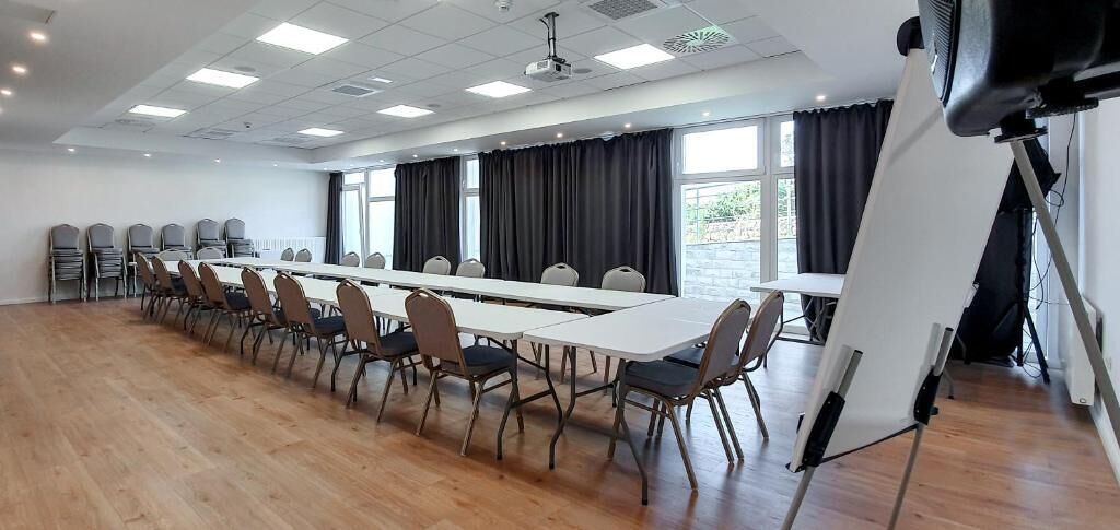 A conference room with a long table, chairs, a projector, and a whiteboard.