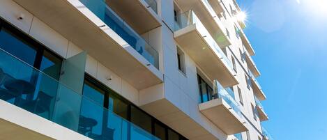A multi-story building with balconies and large windows.