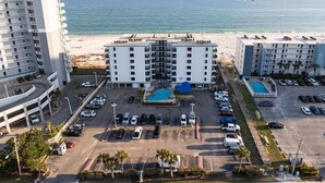 Un hôtel à plusieurs étages, doté d’une piscine et offrant une vue sur la plage.
