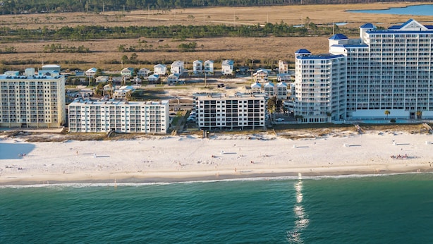 Une station balnéaire dotée de nombreux immeubles de grande hauteur, d’une plage de sable et offrant une vue sur l’océan.