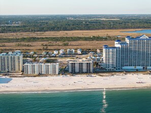 Una località balneare con diversi edifici a grattacielo, una spiaggia sabbiosa e vista sull'oceano.