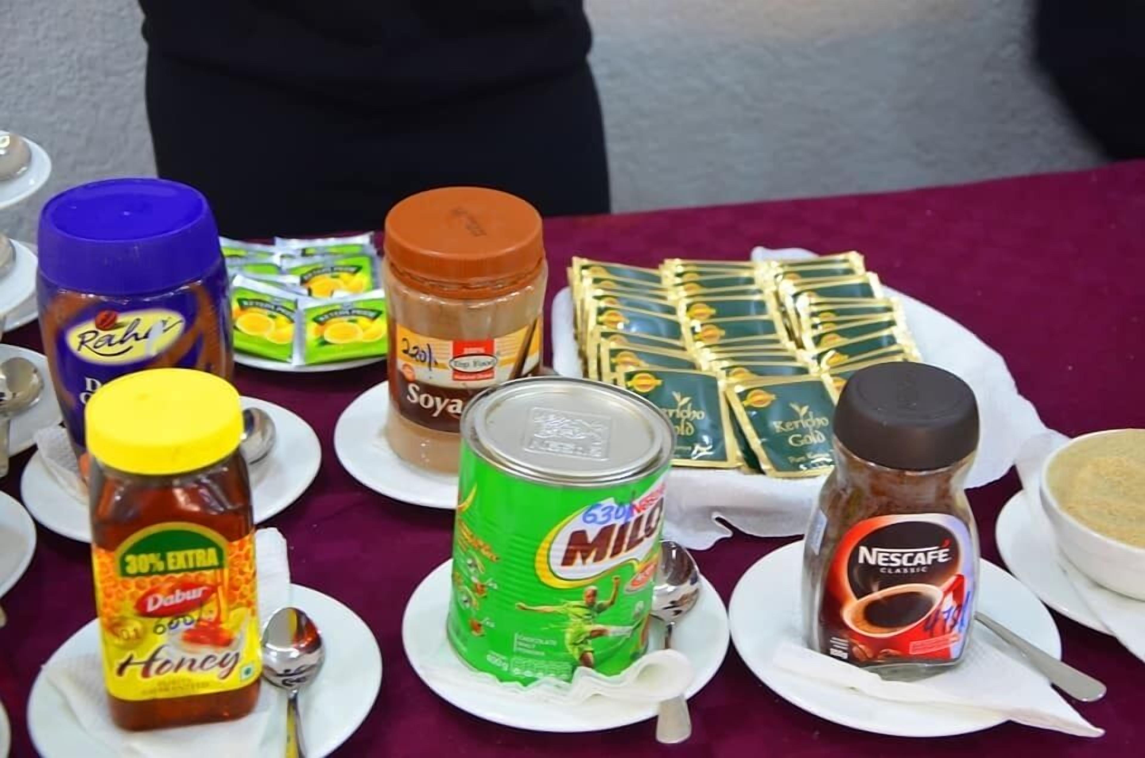 Uma mesa com diversos alimentos, incluindo mel, leite e acompanhamentos.