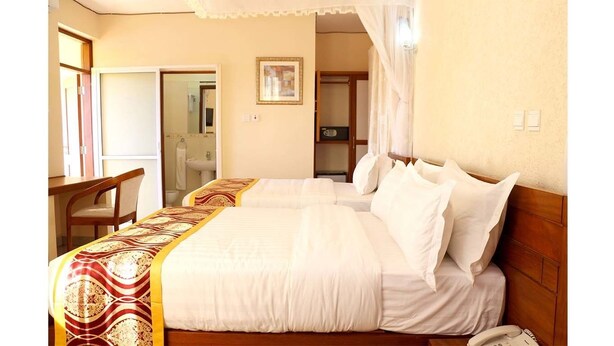 Una habitación de hotel con una cama, un escritorio y una silla.