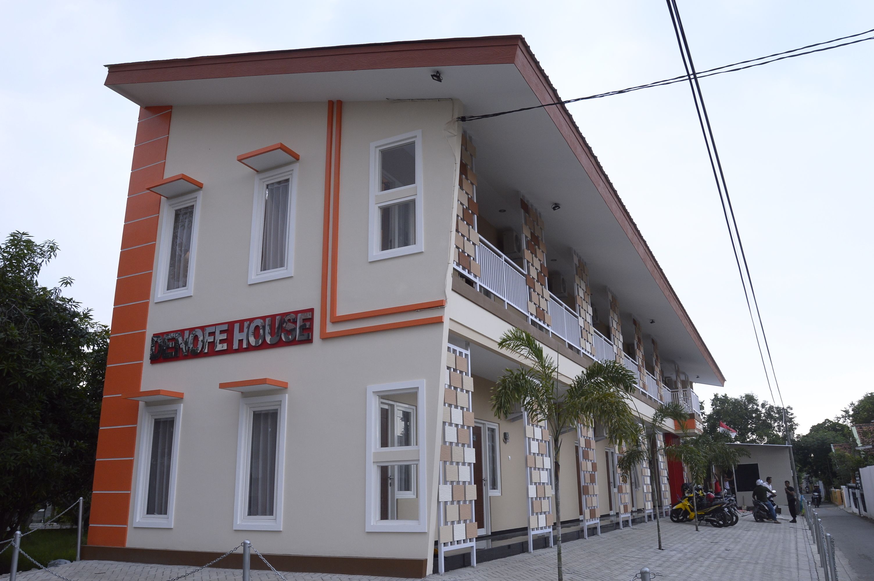 A multi-story building with a sign reading "DENOFIE HOUSE".