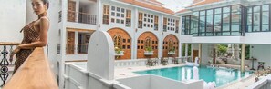 A hotel with a swimming pool, outdoor seating, and a mix of modern and traditional architecture. - Lanna Oriental Hotel (Chiang Mai)