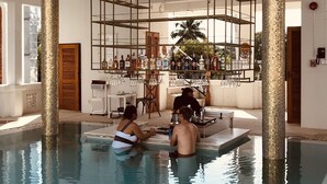 Un área de piscina con bar y sillones de descanso.