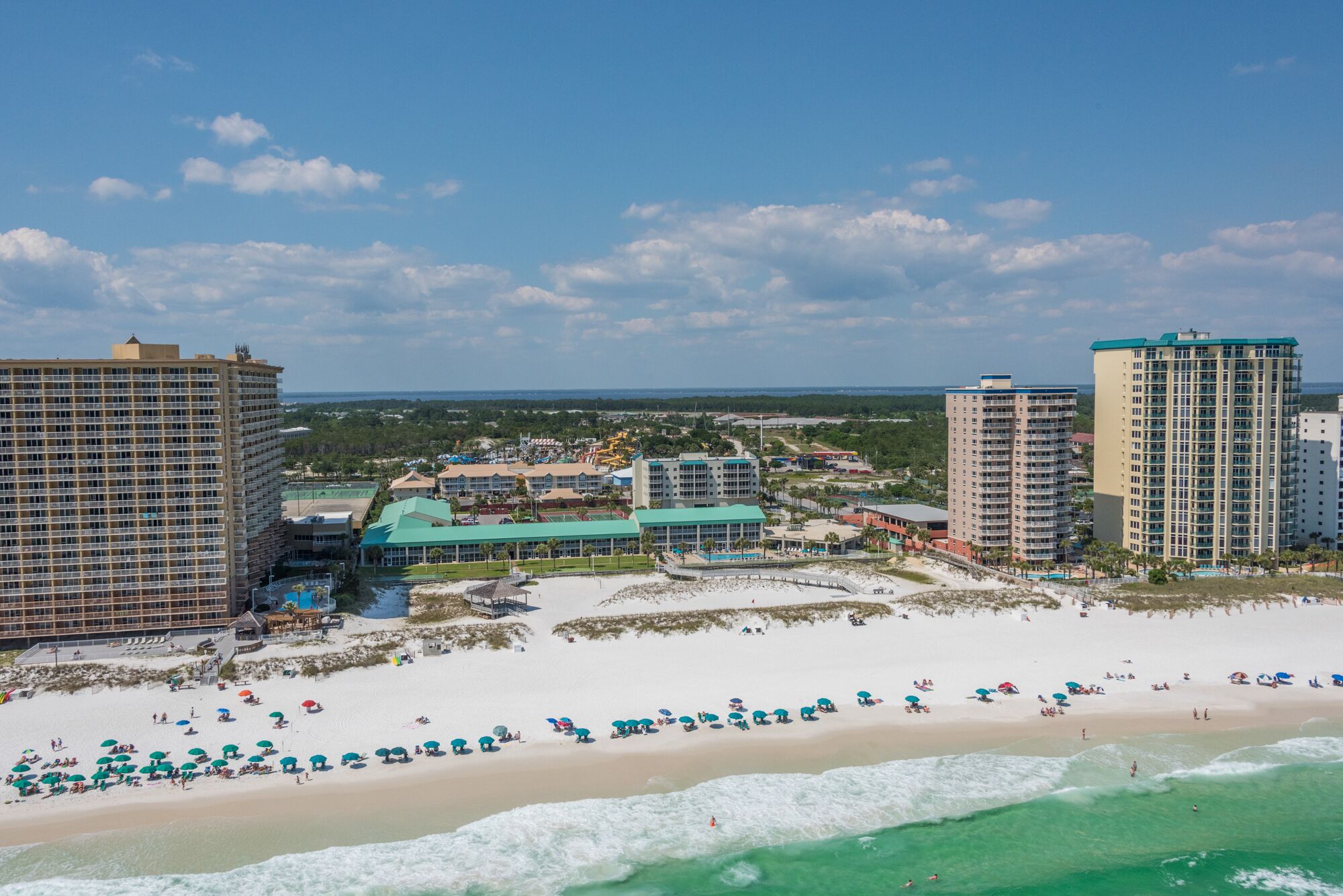A coastal resort with beachfront hotels, a sandy beach, and ocean views.