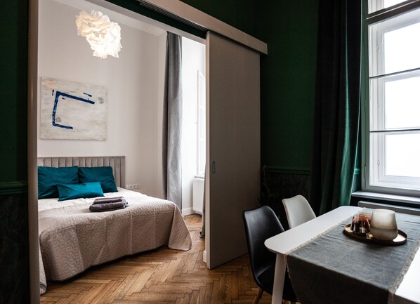 Un dormitorio moderno con una cama, una mesa con una bandeja y vistas al exterior.