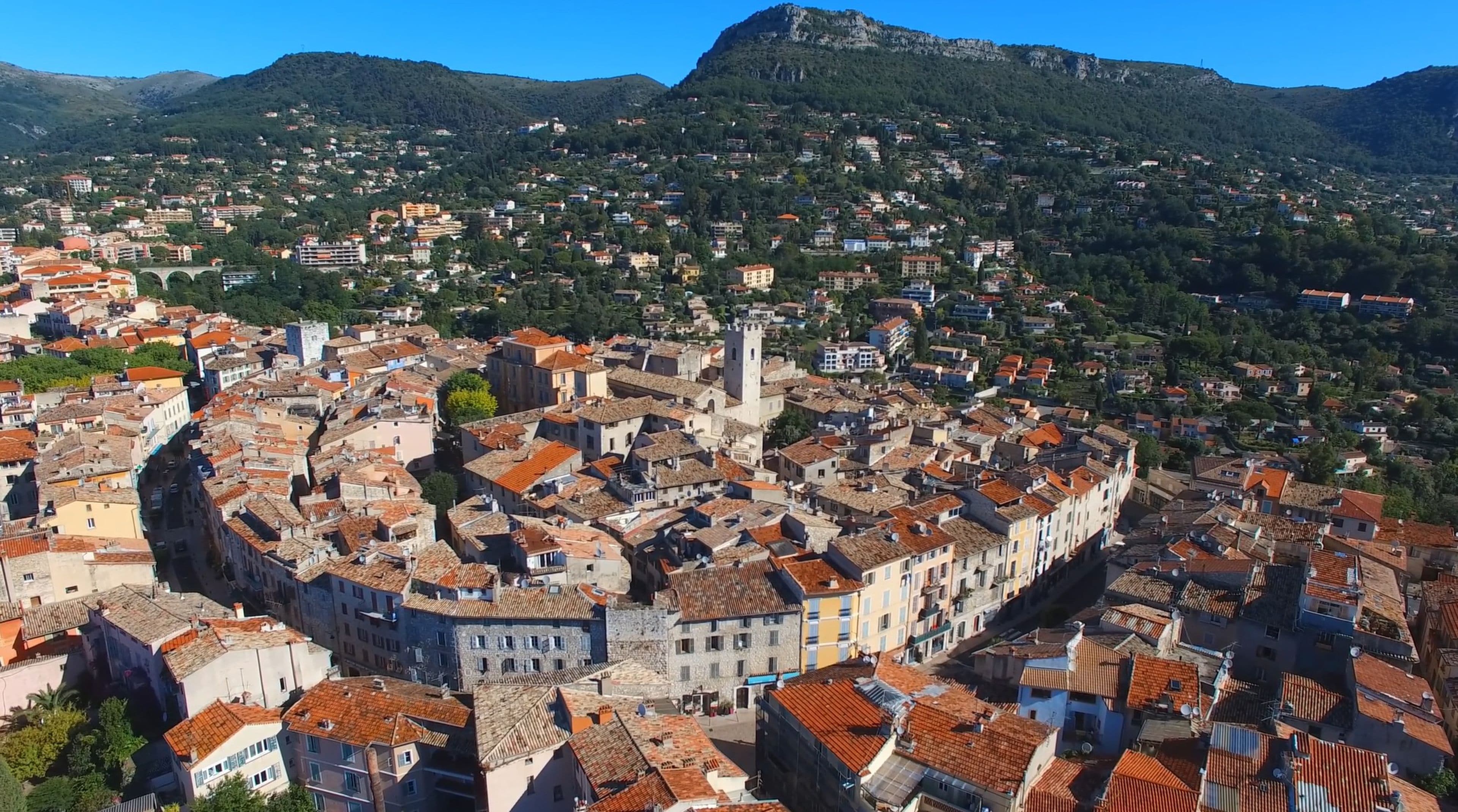 A historic town with a central square, stone buildings, and a prominent tower.