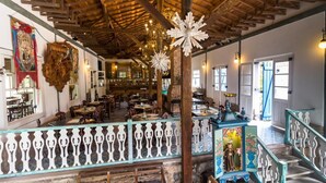 Un comedor amplio con vigas de madera, un balcón con barandillas ornamentadas y vistas al interior.
