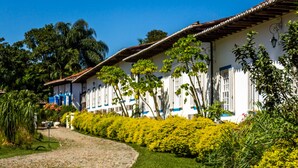 Una hilera de edificios blancos con detalles azules y un camino adoquinado que los conduce.