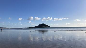 A beach with calm waters and a distant island.
