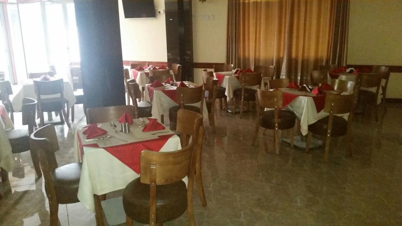 A dining area with multiple tables and chairs, arranged in rows.