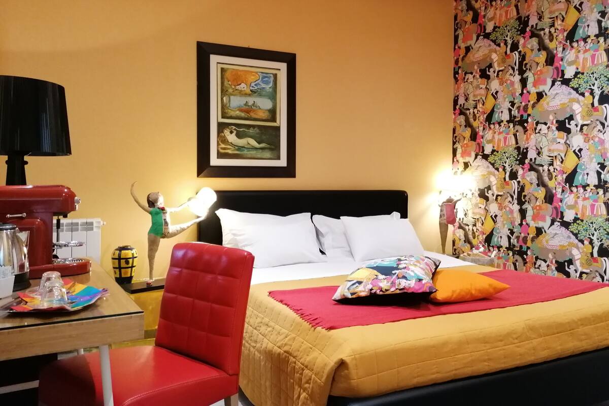Une chambre d’hôtel avec un lit, un bureau doté d’une lampe et une chaise.