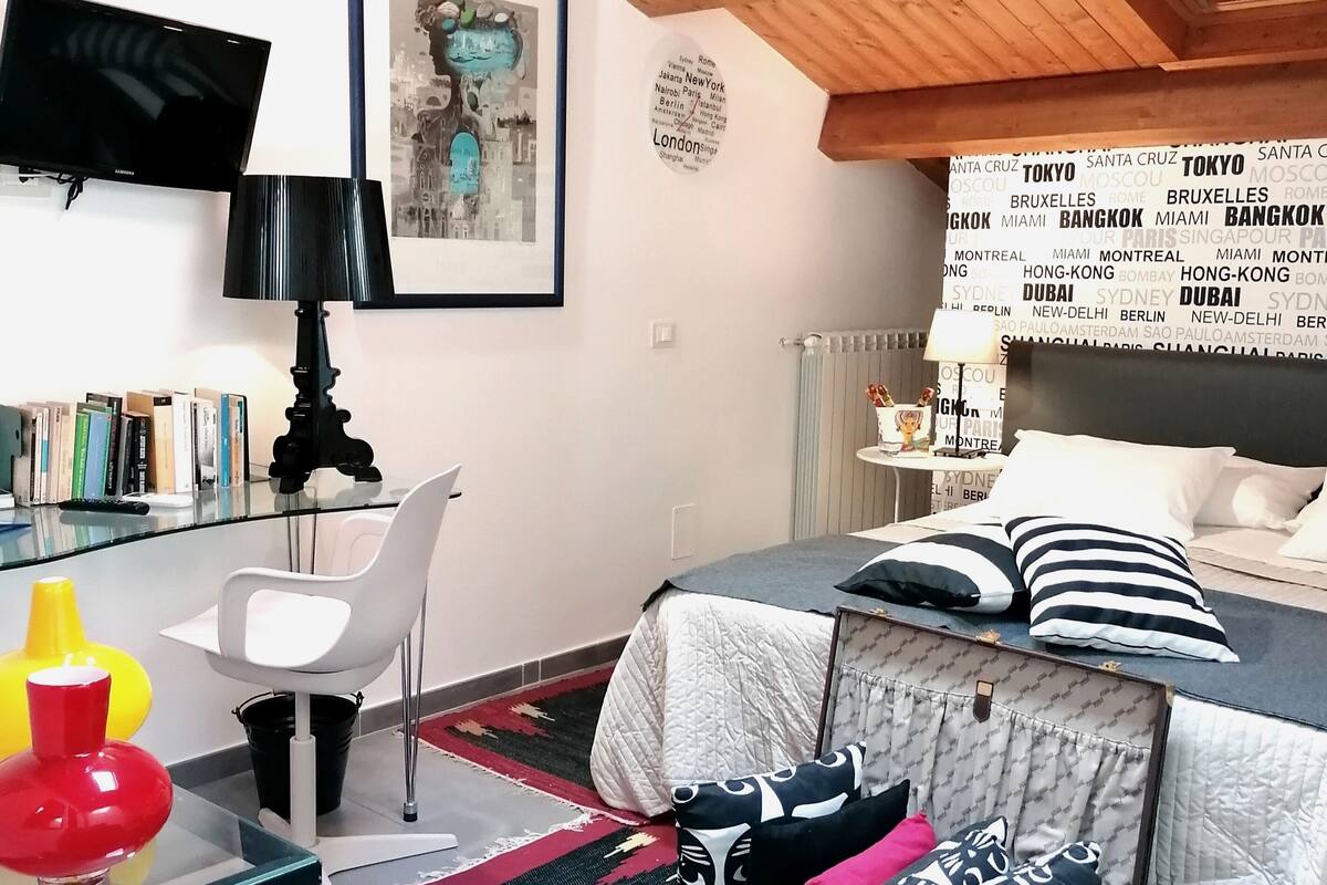 Une chambre à coucher moderne, équipée d’un lit, d’un bureau, d’une chaise et d’un téléviseur.