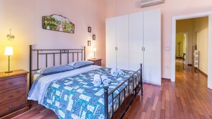 A bedroom with a bed, a nightstand, a wardrobe, and a painting on the wall. - Indipendenza Retreats (Bologna)