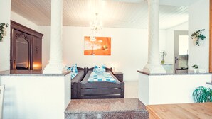 A bedroom with a bed, a nightstand, a wooden bench, and a painting on the wall. - Auberge Leipzig (Leipzig)