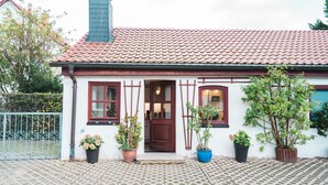 A house with a red-tiled roof, a brown door, and potted plants in front. - Auberge Leipzig (Leipzig)
