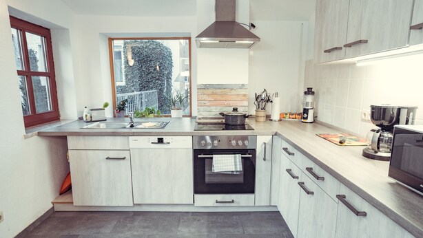 A modern kitchen with a built-in oven, a large window, and a view of the outdoors. - Auberge Leipzig (Leipzig)