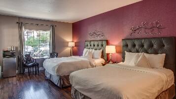 Une chambre d’hôtel avec deux lits, un bureau et une chaise.