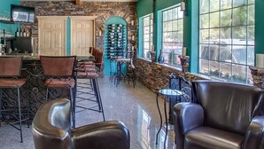 A cozy interior with a bar area, leather chairs, and a stone wall. - Leavenworth Village Inn (Leavenworth)