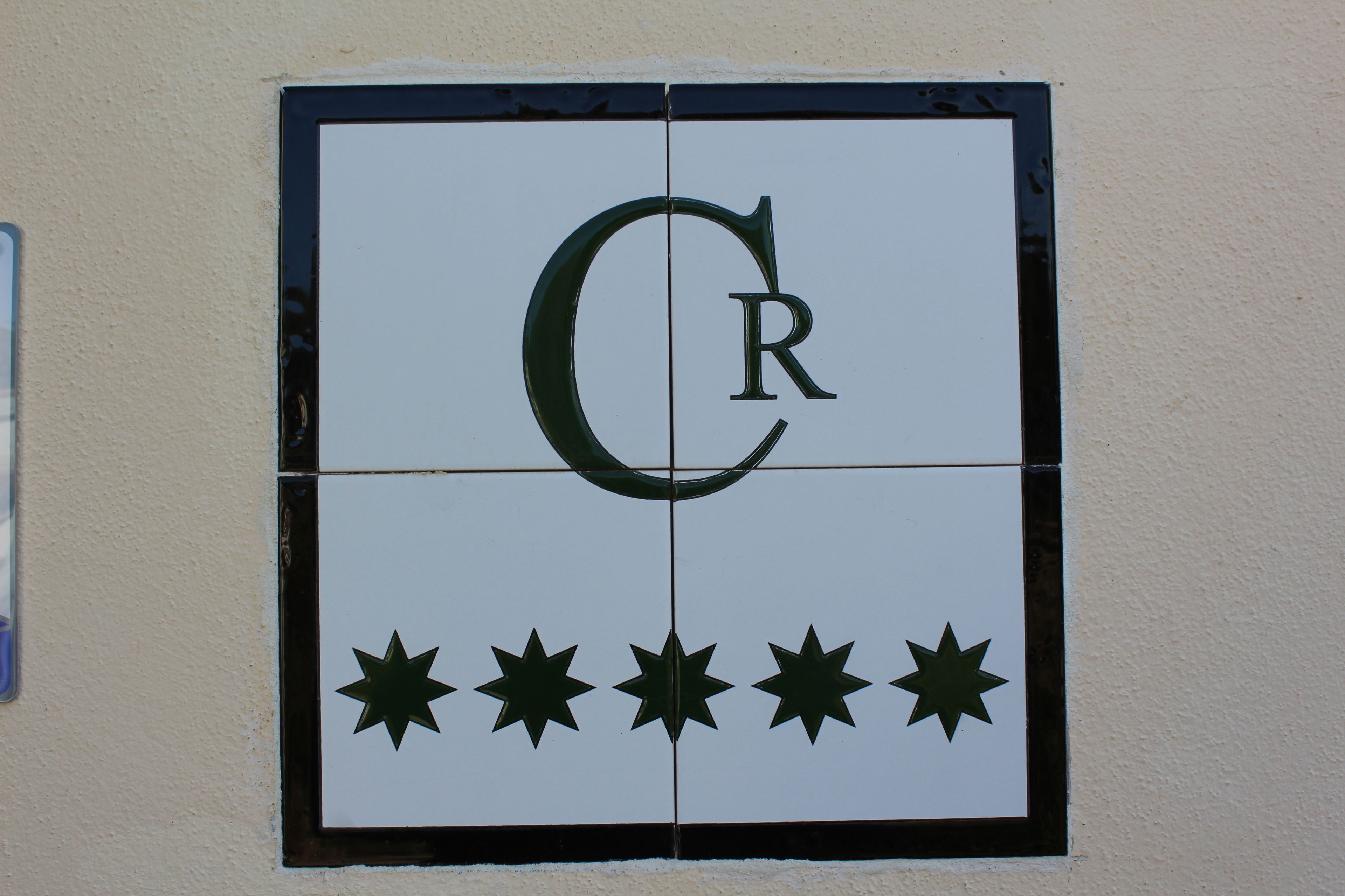 Pared de azulejos con una gran letra 'C' y 'R' en el centro, rodeadas por cinco estrellas.