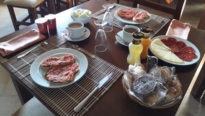 Un desayuno con platos de comida, café y aderezos sobre una mesa.