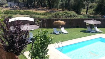 Una piscina al aire libre, sillones reclinables de piscina