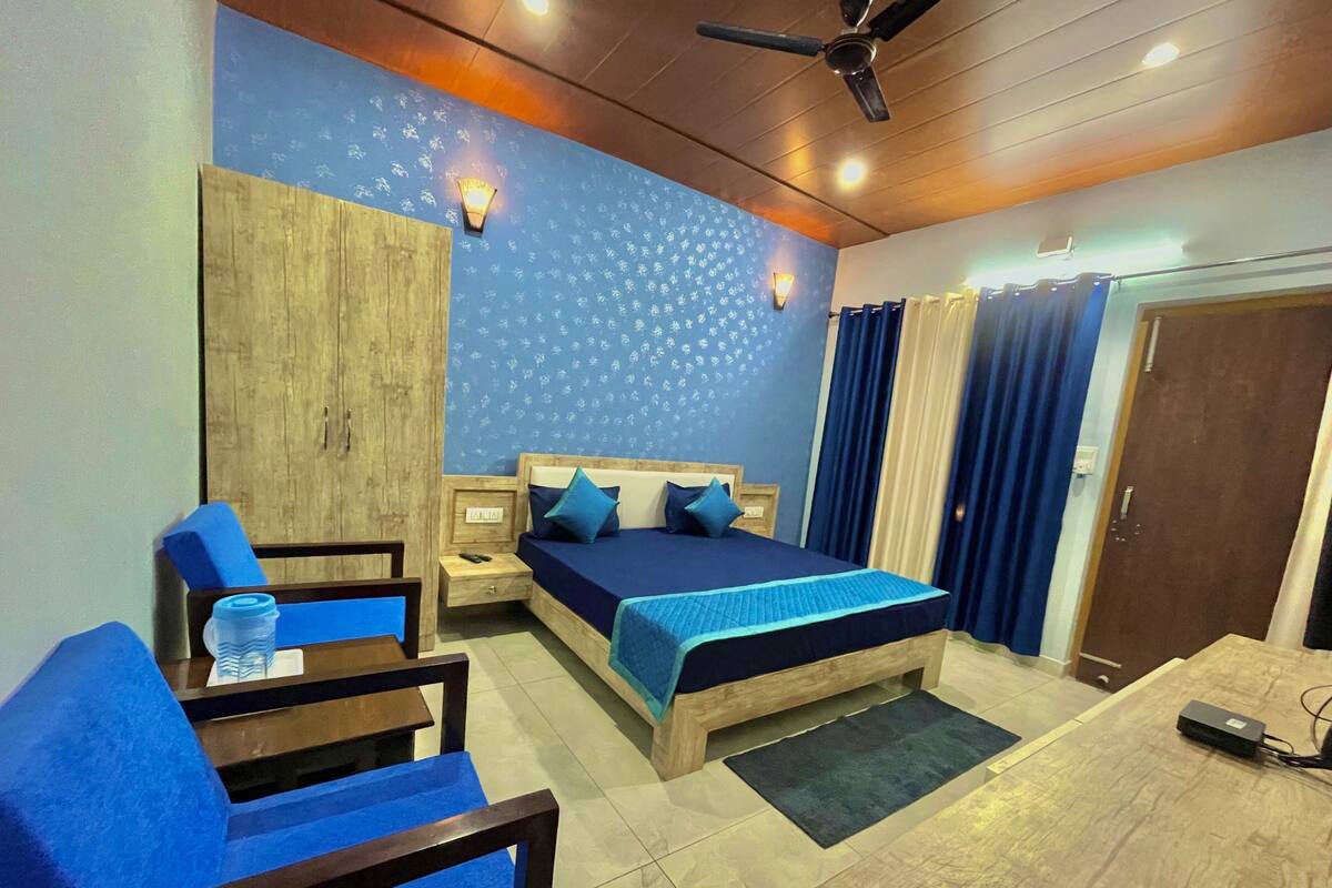 Ein Schlafzimmer mit Bett, Schreibtisch, Stuhl, Kleiderschrank und Deckenventilator.