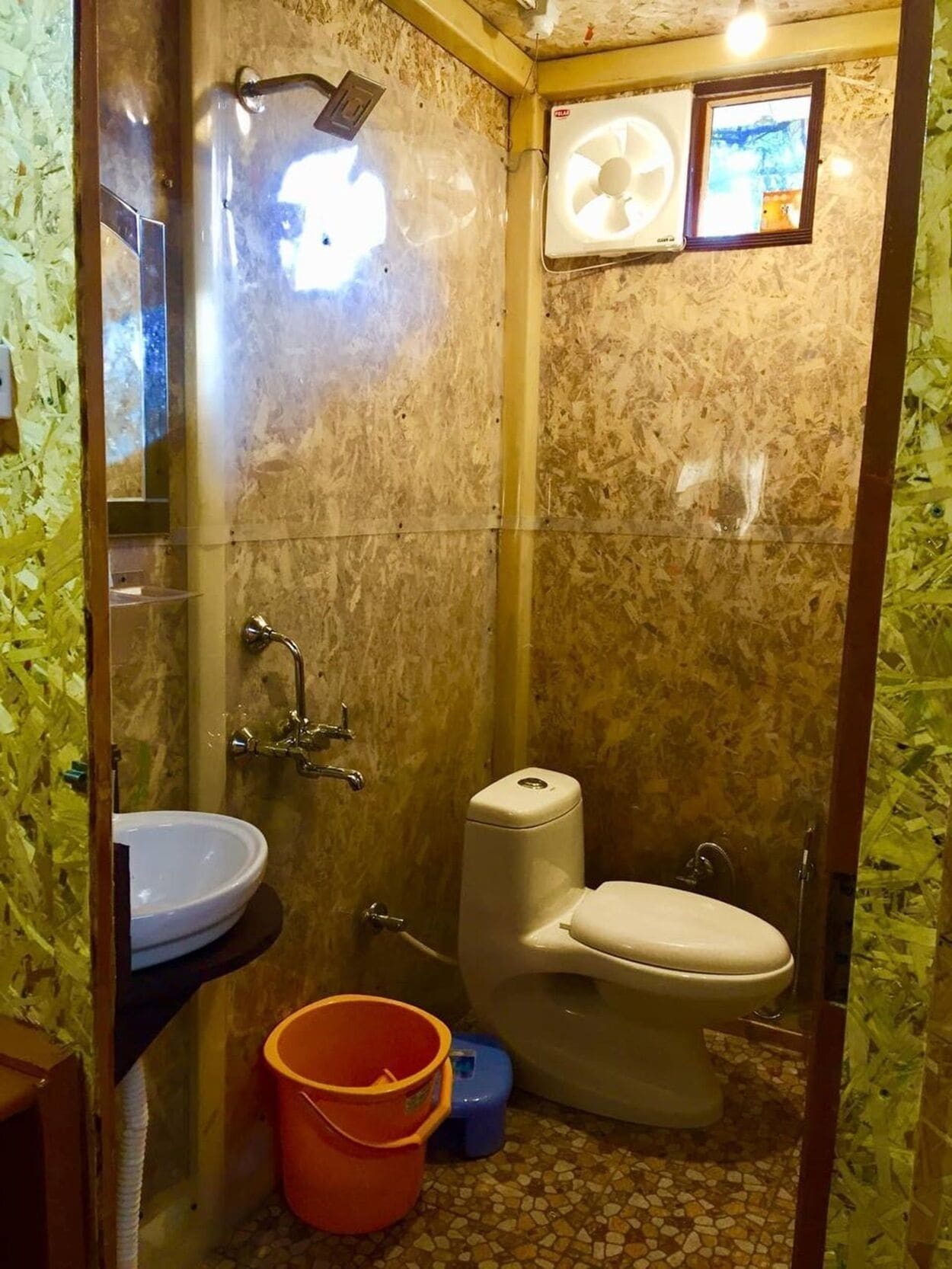 Uma casa de banho pequena com lavatório, sanita e chuveiro.
