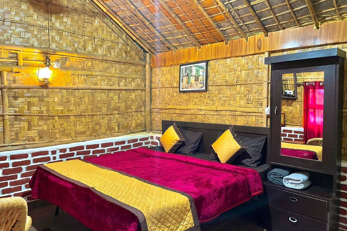 Ein Zimmer mit einem Bett, einem Nachttisch, einem Spiegel und einer Wand mit einem gewebten Muster.