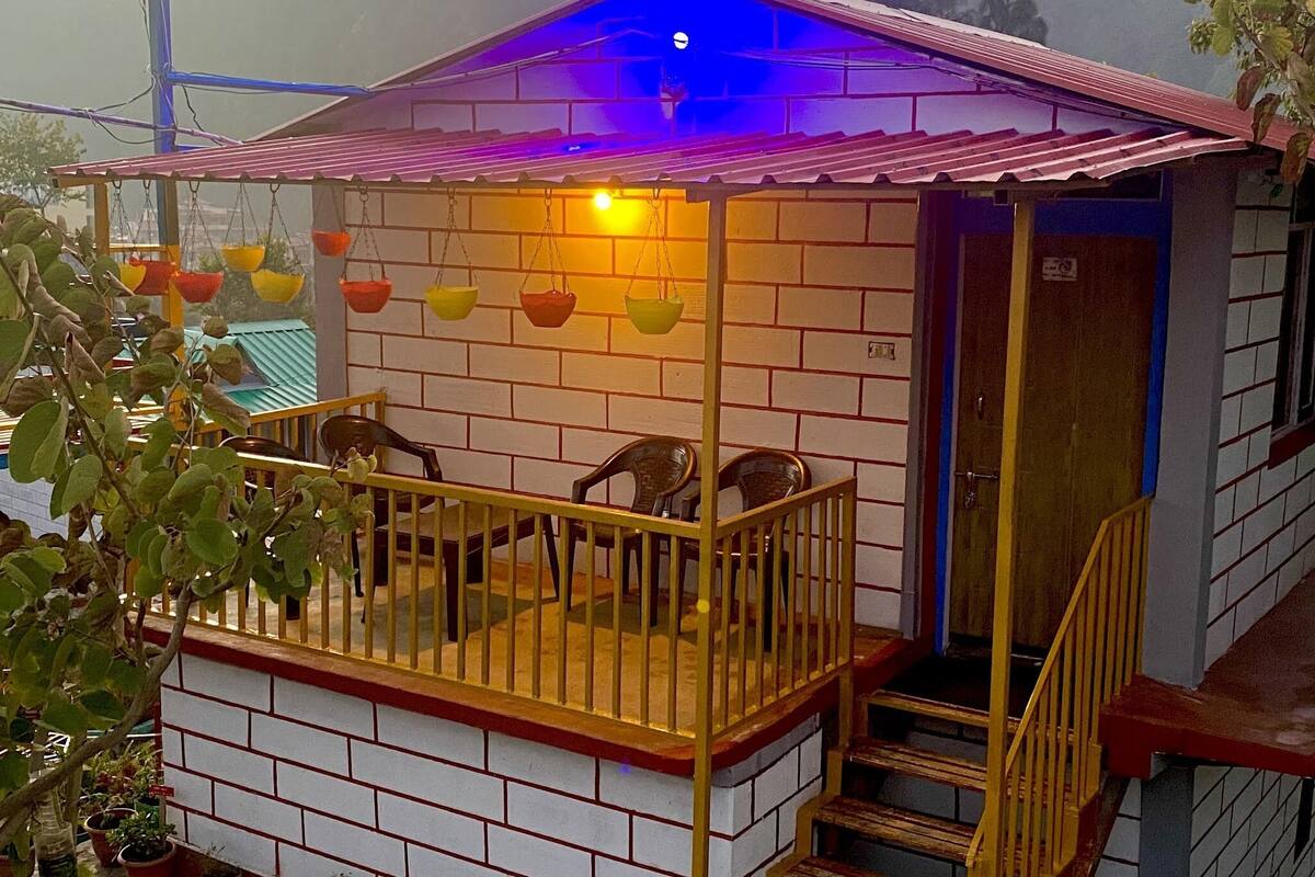 Ein kleines Haus mit Balkon, Holzbalkon und einer Tür.
