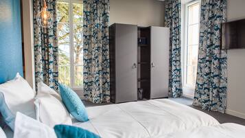 A bedroom with a bed, a wardrobe, and curtains.