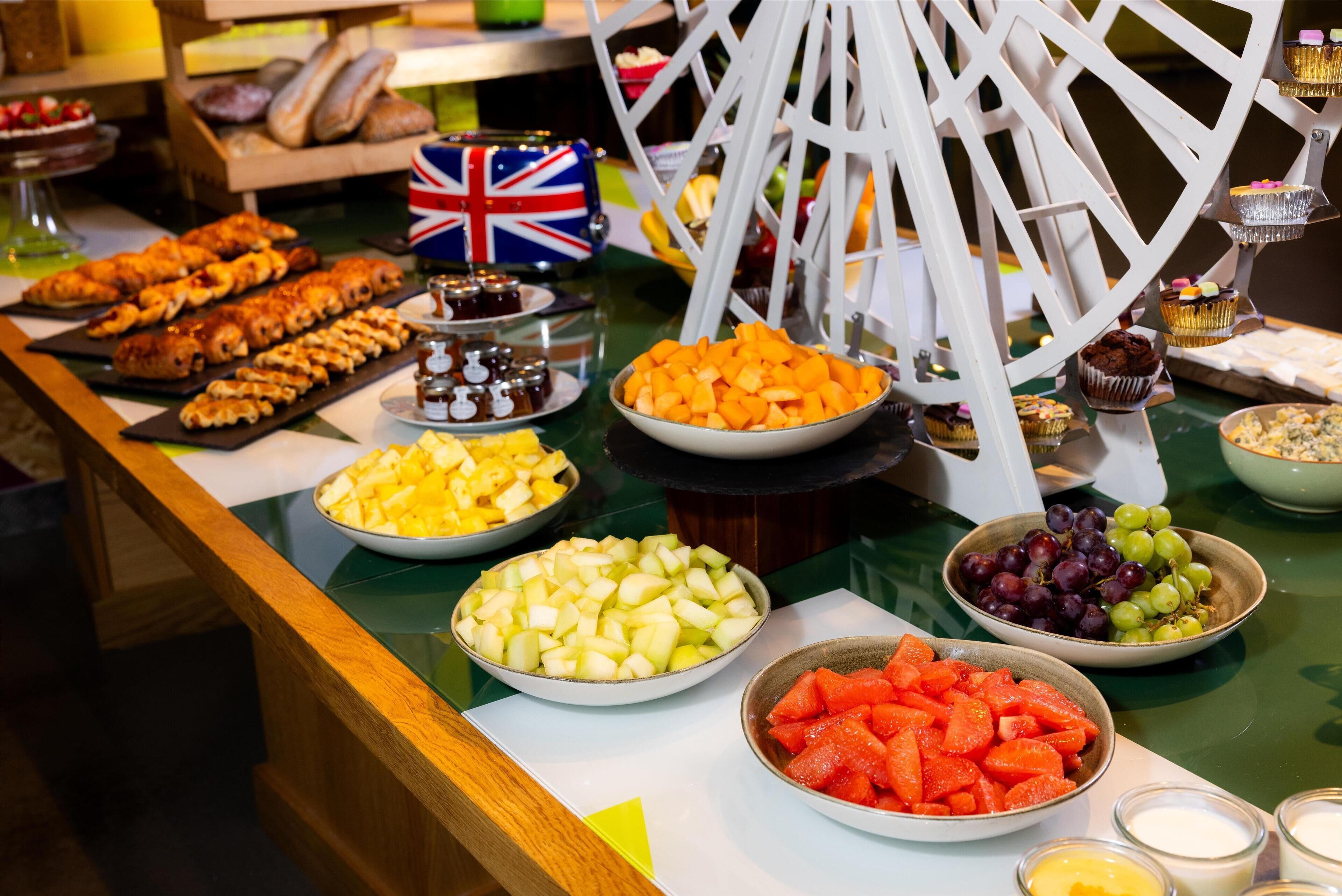 Un buffet proposant une variété de fruits, de légumes et de pâtisseries.