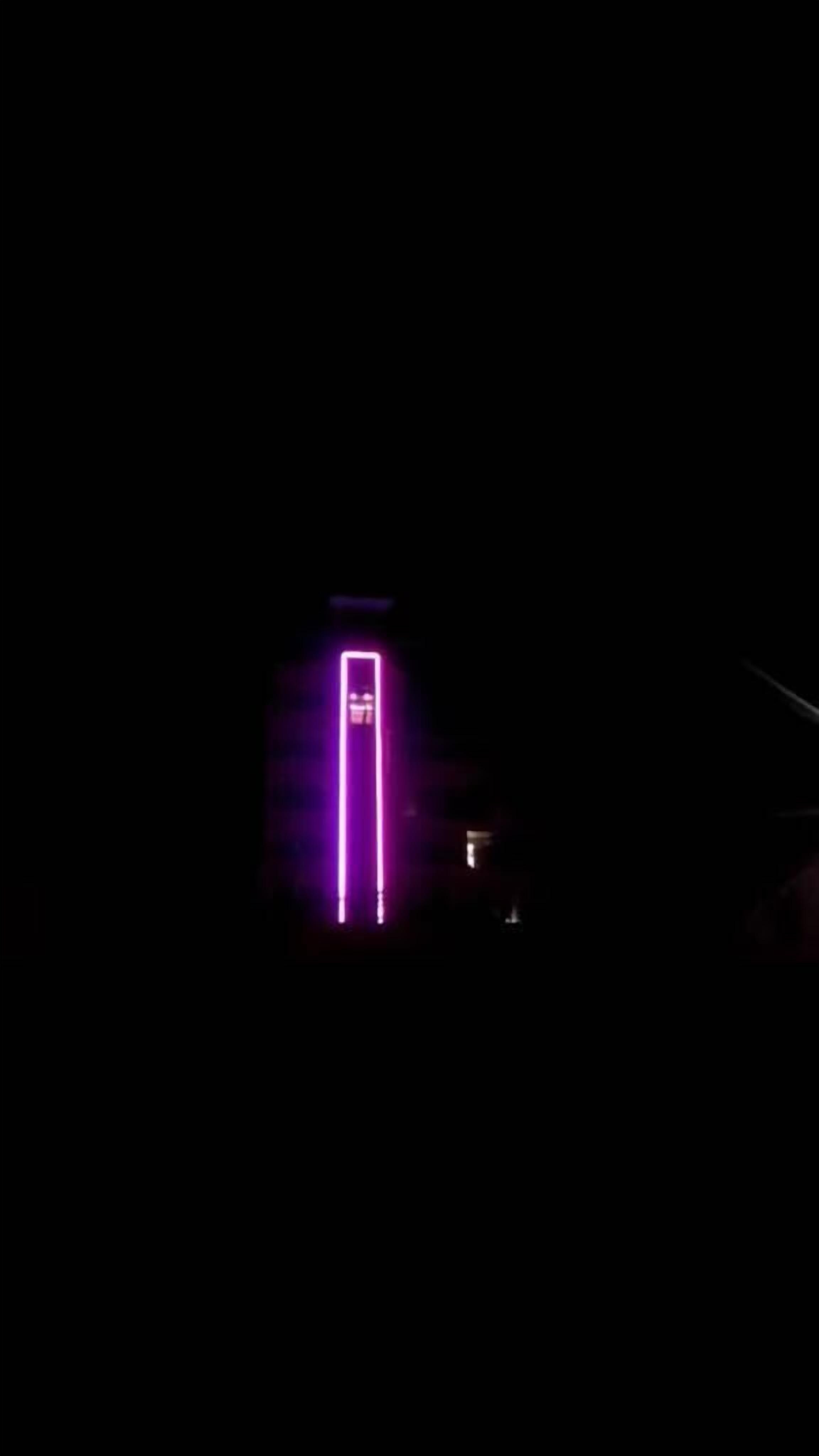 A building with a vertical neon sign.