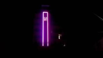 A building with a vertical neon sign.