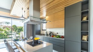 A modern kitchen with a central island, built-in appliances, and a view of the outdoors. - Sofia Luxury Residence (Paphos)