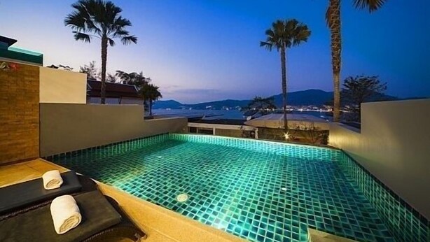 A rooftop infinity pool with a view of palm trees and distant mountains. - Villa 3 oceanfront pool villa (Tambon Patong)