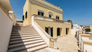 A building with a staircase leading to a balcony. - Villa Dorella (Castrignano del Capo)