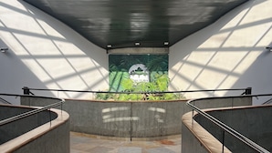 A modern interior with a central atrium, a glass ceiling, and a mural of a crocodile and greenery.