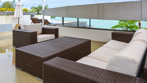 A rooftop terrace with wicker furniture, a large umbrella, and a view of the sea. - Atika Villa 1 oceanfront pool villa (Patong)