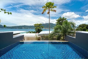 Une piscine à débordement située sur le toit, offrant une vue dégagée sur la mer et les montagnes.