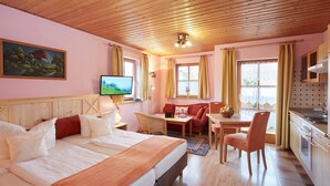 Une chambre d’hôtel confortable avec deux lits, un coin repas et une kitchenette.