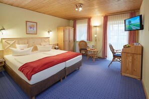 A hotel room with a large bed, a desk, a chair, a television, and a wardrobe. - Land- und Aktivhotel Altmühlaue (Bad Rodach)