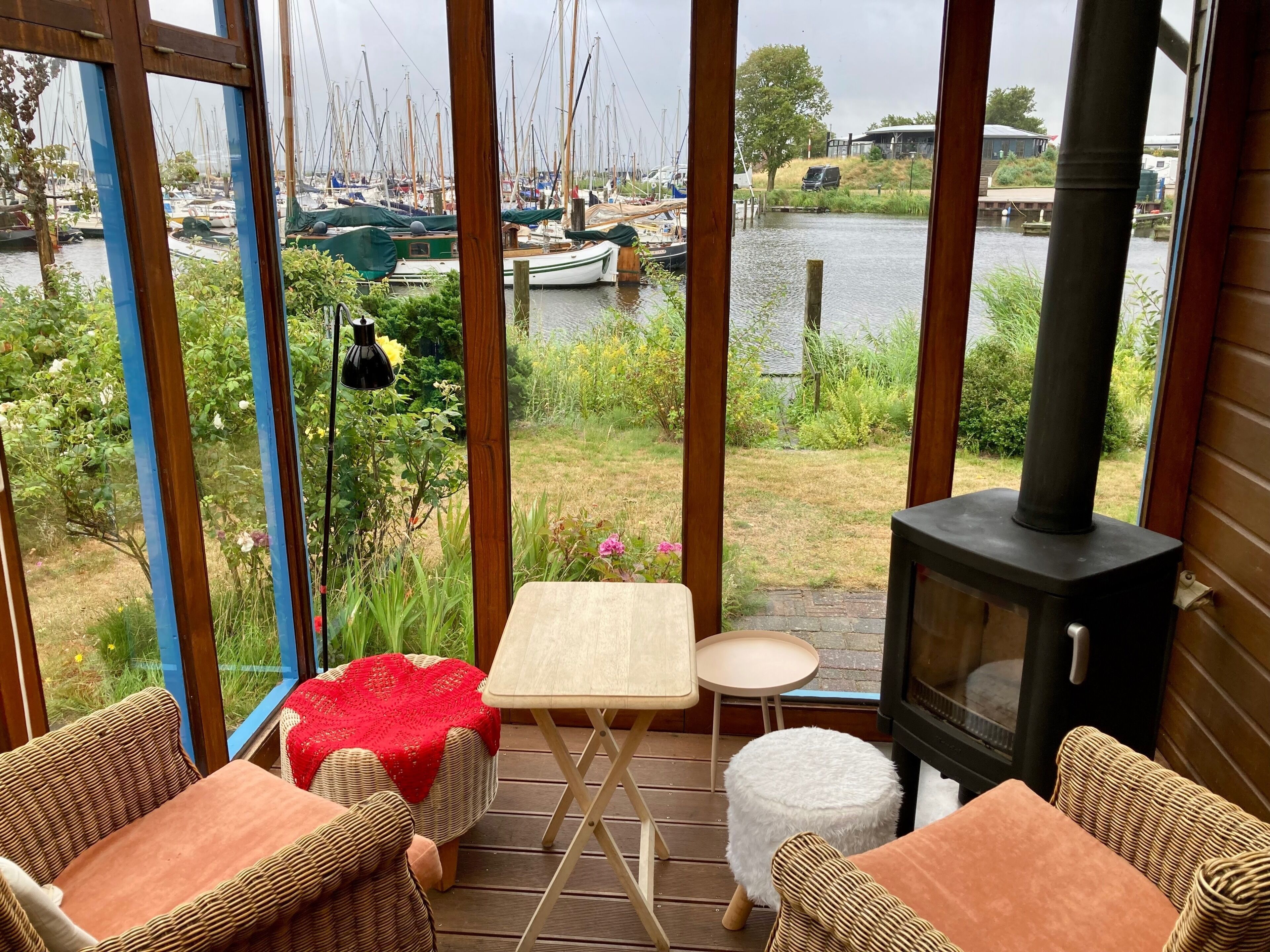 Un cuarto acogedor con vista a un puerto deportivo, una chimenea y muebles de mimbre.