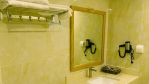 Un baño con inodoro, lavamanos y espejo.