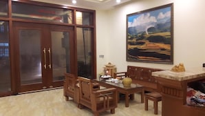 Un comedor tradicional con muebles de madera, un cuadro grande en la pared y un ventanal corredero.